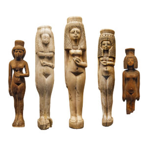 Ancient Egyptian bone figurines of women isolated over a white background.
